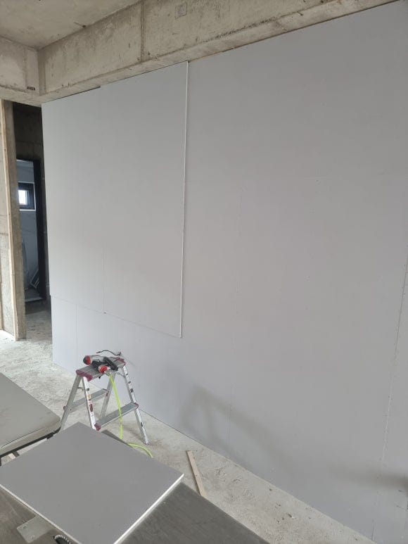 "벽체의 구조적 안정성과 처짐 방지를 위해 규격 목재 뼈대 위에 석고보드를 엇갈려 견고하게 시공하는 가벽 신설 작업 모습"