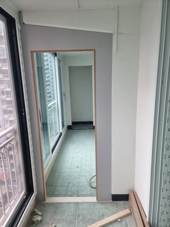 [다용도실 입구] 다용도실 문틀을 철거하고 가벽 없이 벽체와 평면을 이루도록 시공하였으며, 걸레받이가 없는 공간적 특성을 반영하여 9미리 문선 대신 민자 형태로 깔끔하게 제작한 모습.