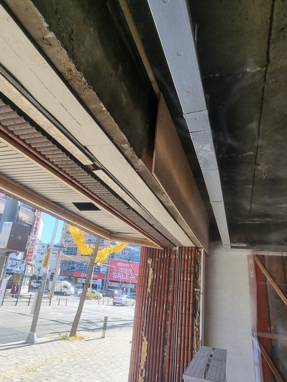 빵집 내부 목샤시 설치를 위한 파사드 작업 전 단계로, 출입구 상부 천장에 길게 목재 틀을 구성한 모습.