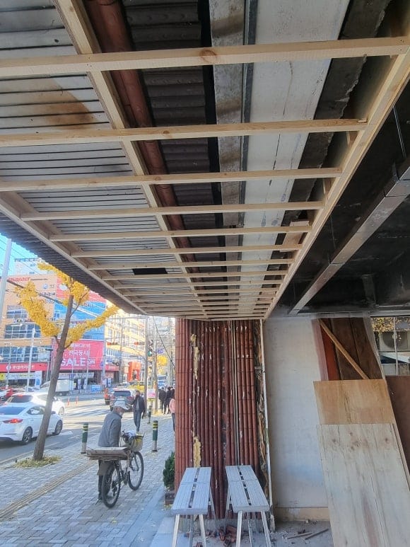 빵집 내부 파사드 천장에 목재가 부착될 수 있도록 일정한 간격으로 목재 틀을 구성한 작업 모습.