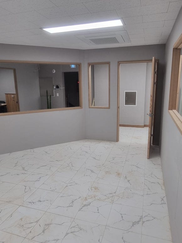 강의실 안에서 바라본 출입문과 큰 통창으로, 벽체 면과 MDF로 제작한 문틀 및 창틀이 구분되어 보이는 상태.