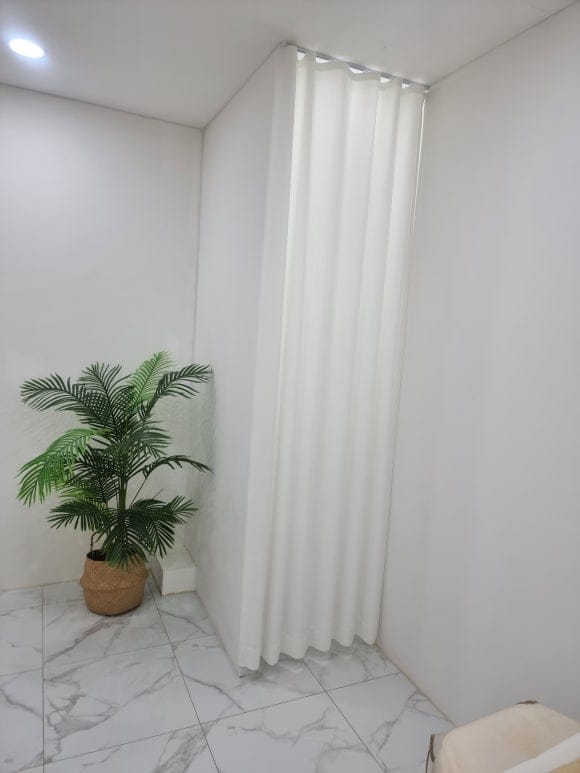 화장실로 이어지는 입구 앞에 작은 가벽을 만들고 천장 커튼을 달아 출입구가 바로 보이지 않게 가린 모습.