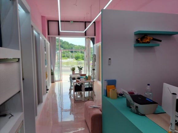 목작업을 마친 뒤 다른 마감 공정이 들어오기 전 상태로, 커튼 전시장과 사무공간 책상 및 가림벽의 전체 배치를 확인할 수 있는 매장 내부.