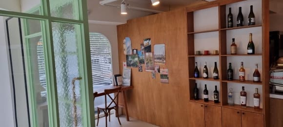 목재 파티션과 이어진 수납 파티션의 정면 모습으로, 상부 진열칸과 하부 문짝 수납장을 함께 제작한 카페 와인장.