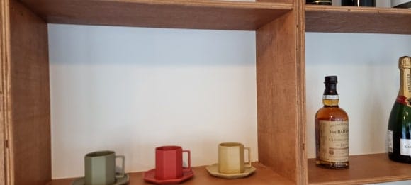와인장 상부 진열칸의 뒷판에 MDF를 별도로 덧대고 흰색 페인트로 마감해 목재 선반과 구분되도록 제작한 모습.