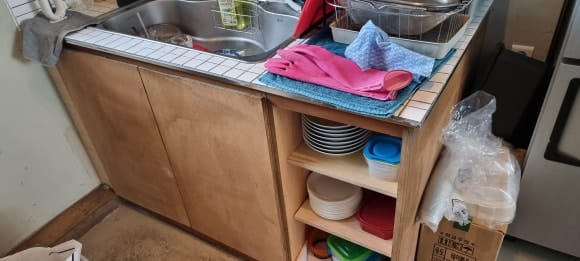 카페바 뒤쪽에 합판으로 제작한 싱크대 하부장과 개방형 수납공간이 나란히 배치된 모습.