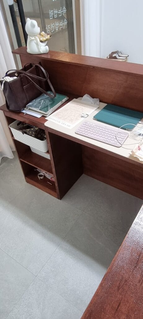 카드결제기와 사인패드를 올릴 수 있도록 상판 폭을 넓히고, 의자 자리와 양쪽 수납공간을 함께 만든 카운터 안쪽 모습.