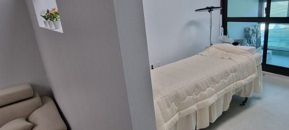 각재로 틀을 세우고 앞뒤에 석고보드를 두 겹씩 붙여 시술 침대 공간을 구분한 파티션 벽의 측면 모습.