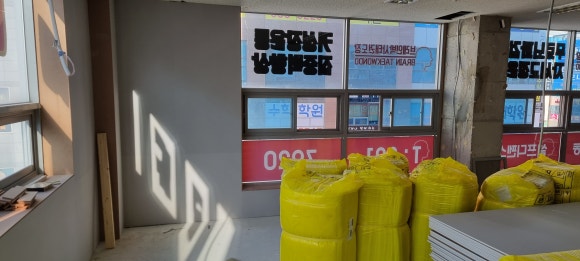 사진 39. 복도 쪽에서 바라본 강의실 벽체 공사 과정으로, 통창 개구부와 출입문 위치가 순서대로 만들어지고 있습니다.