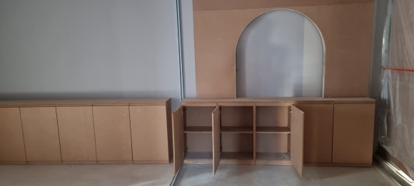 사진 24. 대기실 맞춤 하부장의 문을 열어 내부 수납칸과 중앙 책상 형태의 공간을 확인할 수 있는 목공 마감 전 모습입니다.