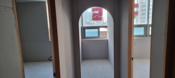 사진 31. 복도 끝 창고 입구의 아치형 게이트를 제작한 공사 중 모습으로, 안쪽 창가 공간까지 이어지는 구조입니다.