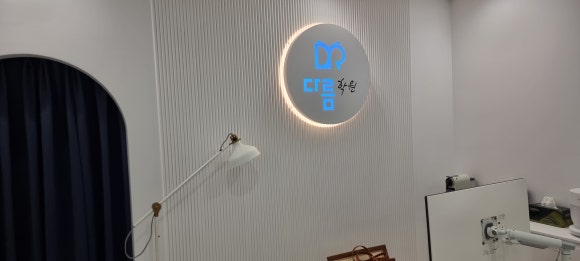 사진 6. 원장실 외부 벽면에 템바보드를 설치하고 소형 간판을 더한 모습으로, 템바보드는 목공 작업 범위에 포함된 부분입니다.