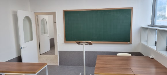 사진 19. 강의실 전면 벽에 칠판을 설치할 수 있도록 벽체 보강을 마친 모습으로, 칠판과 양쪽 출입문이 함께 보입니다.