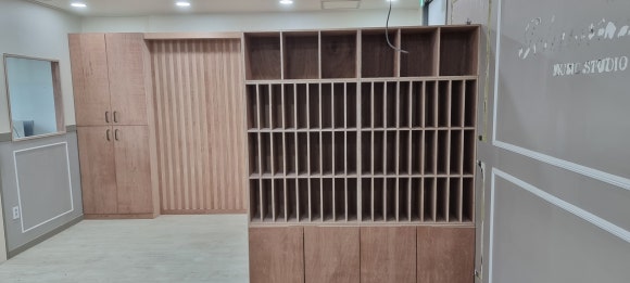 사진 11. 목공 작업을 마친 뒤 촬영한 입구 공간으로, 기존 수납장에 새 문짝을 달고 옆에 책꽂이 장을 세운 모습.
