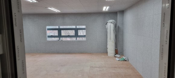 사진 12. 방음 시공이 완료된 실내를 출입구 쪽에서 바라본 모습으로, 사면 벽체와 천장 마감 및 외부 창문 쪽 방음 구조가 함께 보입니다.