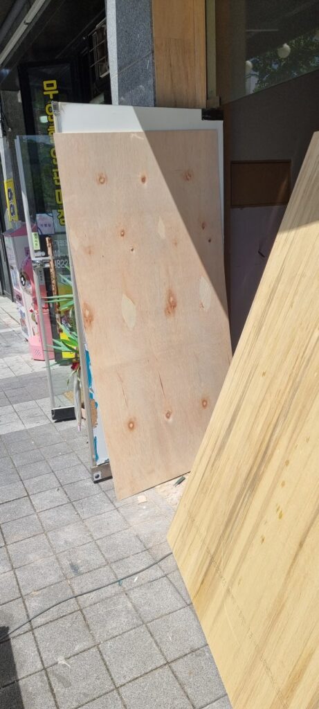 사진 41. 기존 샤시 리폼과 내부 목공에 사용할 합판을 매장 외부에 세워 두고 작업을 준비한 모습입니다.