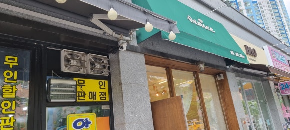 사진 7. 주변 점포의 기존 금속 샤시와 목재로 리폼한 쥬얼리샵 외관을 비교해 볼 수 있는 건물 전면 모습입니다.