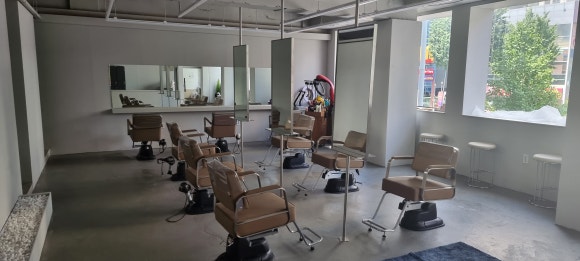 사진 1. 부산 연산동 약 40평 미용실 입구에서 바라본 모습으로, 정면 양면 거울 좌석 6개와 안쪽 벽면 거울 좌석이 배치되어 있습니다.
