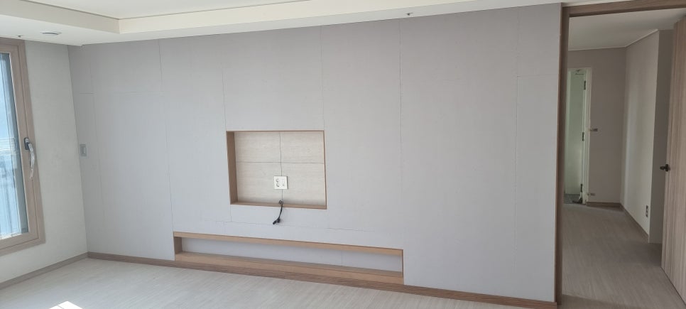 사진 9. 하부 간접조명 스위치를 끈 상태의 TV 반매립 벽으로, 조명이 꺼진 매입선반과 중앙 TV 설치 공간의 구조가 보인다.