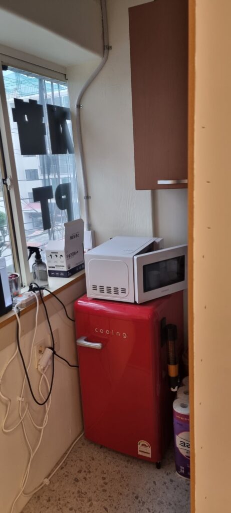 사진 8. 탕비실 창가 쪽에 전자레인지와 냉장고가 배치되어 있으며, 사장님이 혼자 사용하는 내부 공간의 모습입니다.