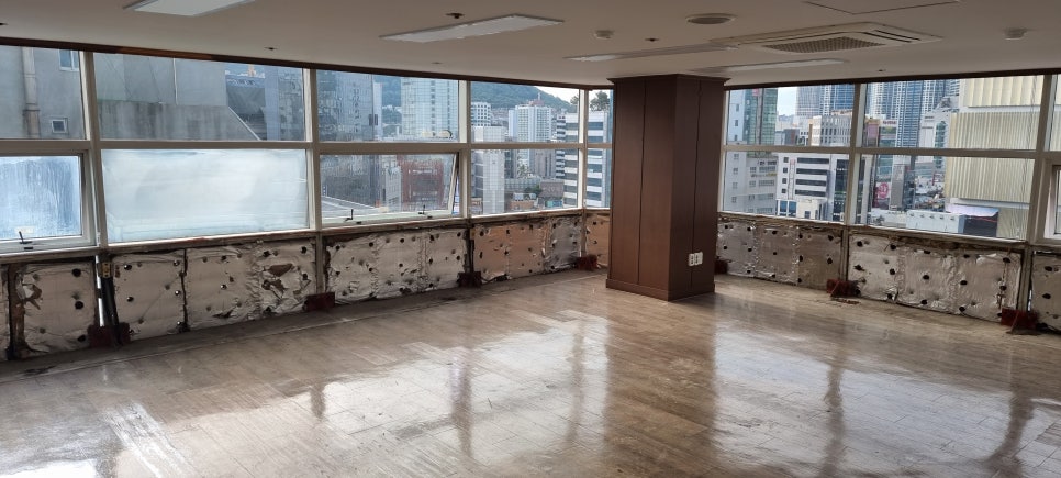 사진 2. 사무실 창문을 따라 하부 마감이 모두 철거되어 있으며, 천장 가장자리에는 오래된 체리색 몰딩이 남아 있습니다.