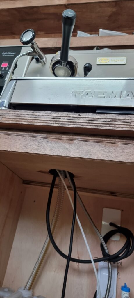 사진 13. 커피머신이 올라간 상판과 하부 공간을 가까이서 본 모습으로, 두꺼운 상판 아래쪽으로 장비의 전선과 배선이 내려가는 상태가 보입니다.