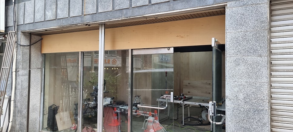 사진 31. 매장 외부에서 바라본 공사 중 입구 모습으로, 기존 샷시 주변과 입구 상부가 아직 마감되기 전 상태입니다.