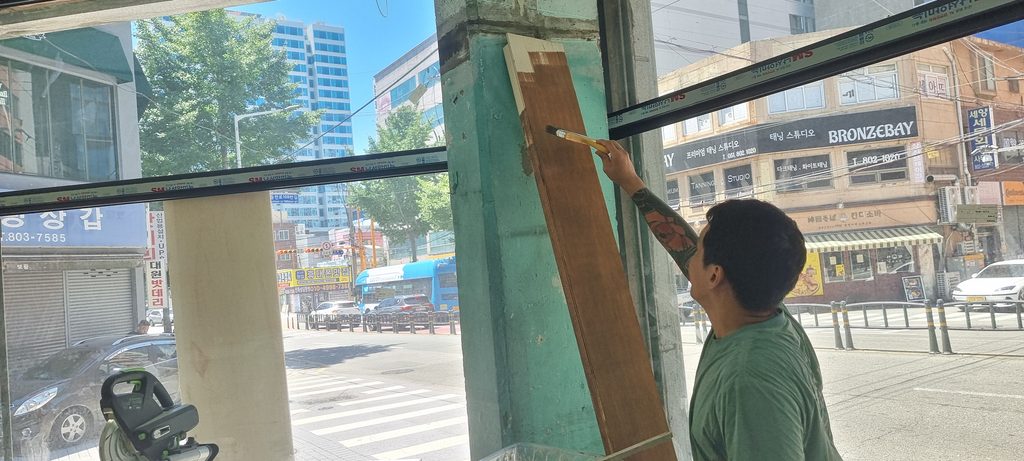 사진 14. 창가 기둥 안쪽에 오일스테인을 칠하고 있는 모습으로, 기둥을 설치한 뒤에는 샤시와 가까워 페인트 작업이 어려울 것으로 판단해 집주인이 미리 월넛색 오일스테인을 칠하고 있습니다.