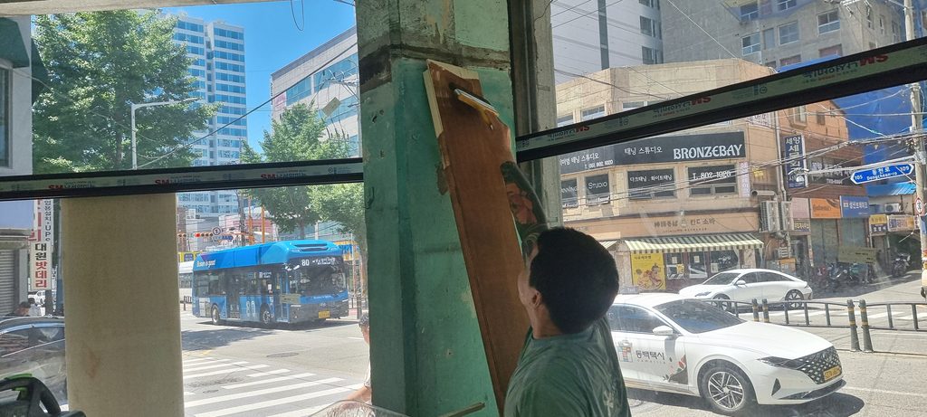 사진 15. 창가 기둥의 다른 면에 오일스테인을 붓으로 바르고 있는 모습으로, 별도의 복잡한 작업 없이 붓으로 직접 칠해 목재에 색을 입히고 있습니다.